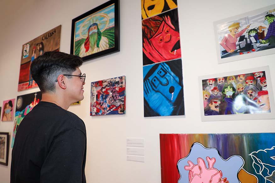 A student examines artwork at the Steppling Art Gallery