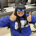 Student wearing HoloLens looking at camera giving two thumbs up