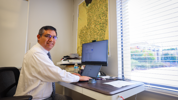 lab instructor smiling next to his desk